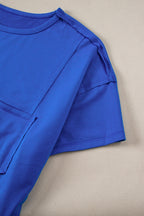 Blue oversized T-shirt by Mommas Hive with patched pocket and exposed seams, made from polyester, cotton, and elastane.