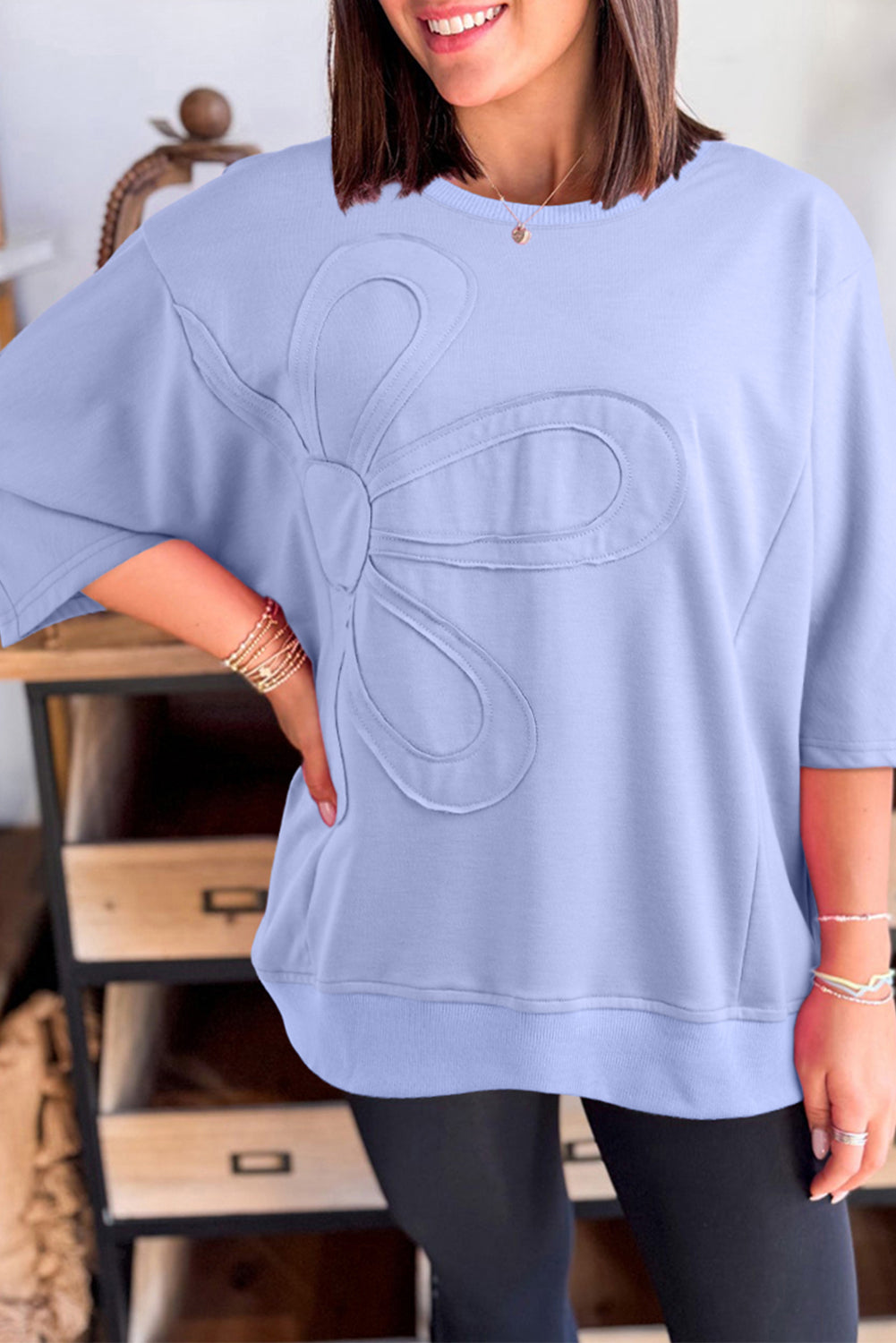Mommas Hive floral patched half sleeve tunic top in aqua, made of polyester, cotton, and elastane, displayed on a hanger.
