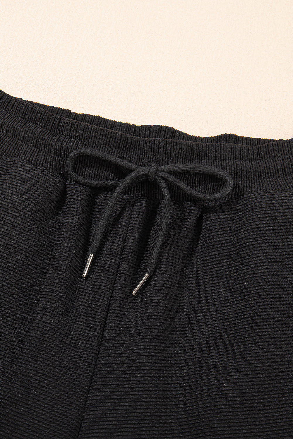 Black textured two-piece set with ruffled sleeve zipped top and wide-leg pants by Mommas Hive, made of polyester and elastane.