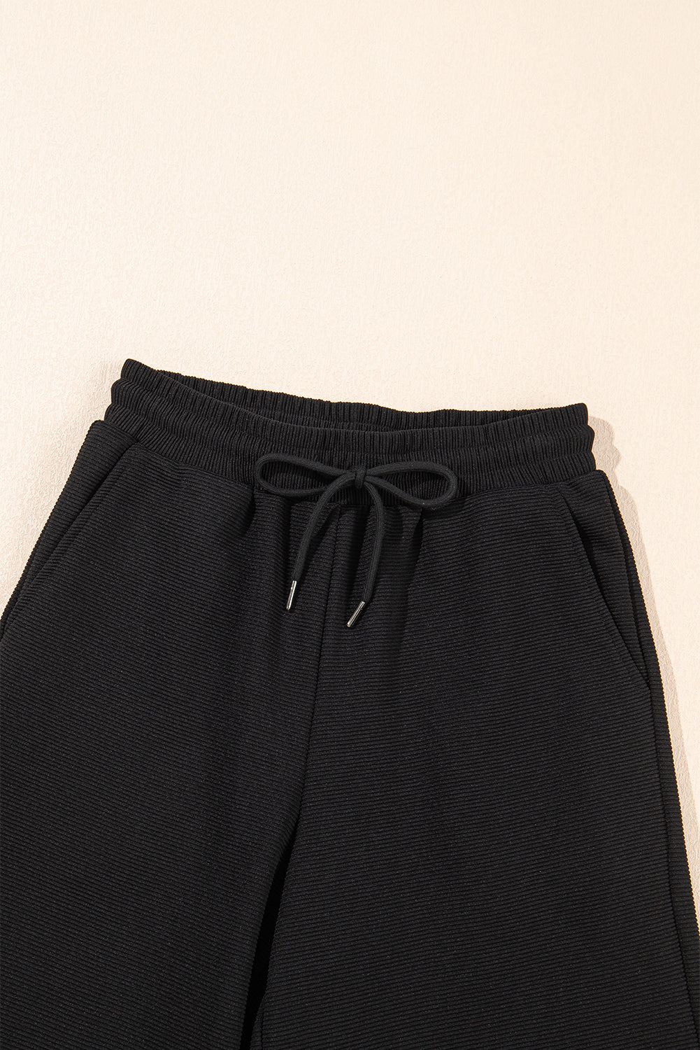 Black textured ruffled sleeve zip-up top with wide-leg pants set by Mommas Hive, featuring polyester-elastane fabric and stylish design.