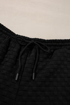 Black checkered textured split pullover top and matching pants set from Mommas Hive, stylish two-piece outfit for casual wear.