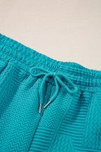 Mommas Hive textured ruffle split top with matching drawstring shorts, two-piece set, polyester and elastane fabric, stylish and comfortable.