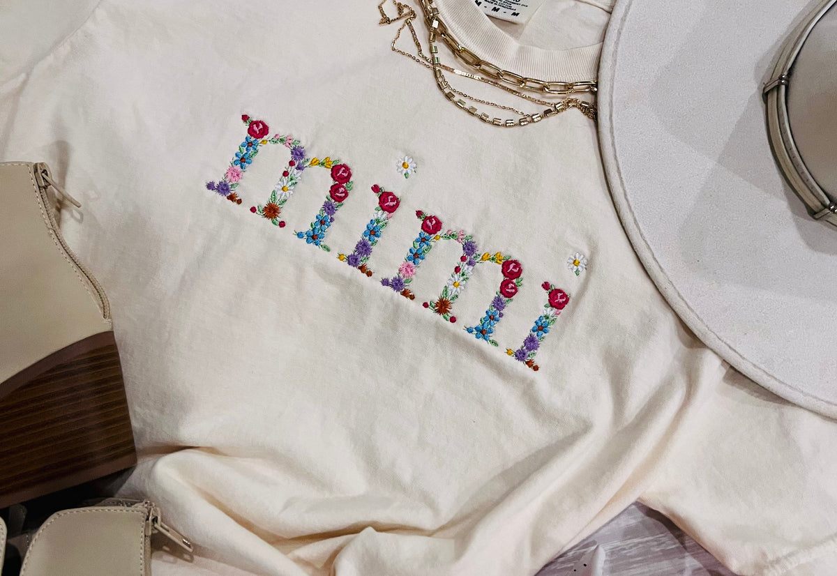 Blue Mimi floral embroidered tee by P&PD Wholesale, featuring intricate floral embroidery on soft fabric.