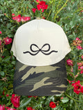 Camo embroidered bow hat by P&PD Wholesale featuring a stylish camouflage pattern and decorative bow detail.