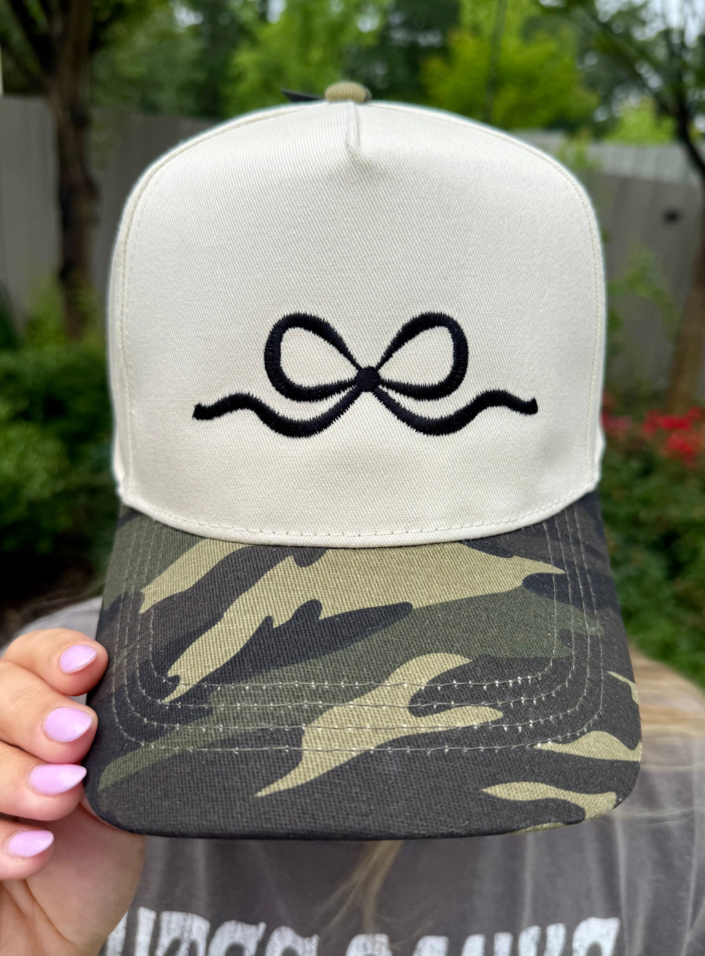 Camo embroidered bow hat by P&PD Wholesale featuring a stylish bow detail and camouflage pattern.