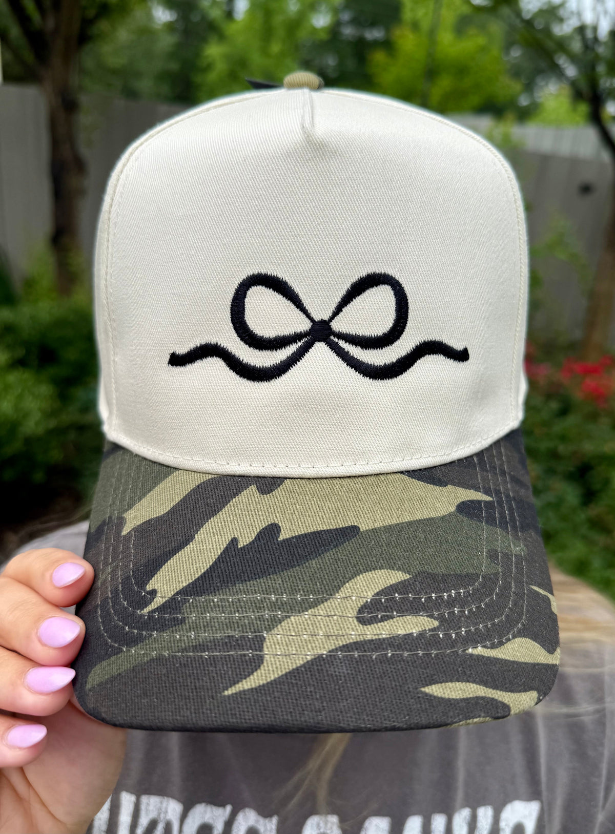 Camo embroidered bow hat by P&PD Wholesale featuring a stylish bow detail and camouflage pattern.