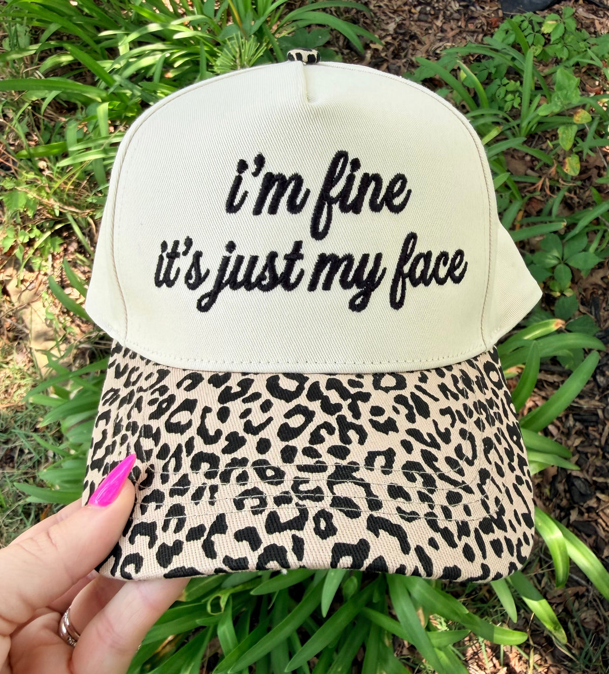 Leopard face hat from P&PD Wholesale featuring bold animal print and humorous "I'm Fine, It's Just My Face" text.