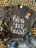 Heather charcoal "Bless Your Heart" sign by P&PD Wholesale, featuring bold lettering on a rustic wooden background.