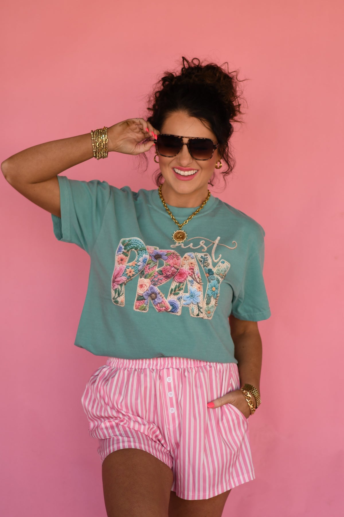 Seafoam green Just Pray Floral Rope Tee by P&PD Wholesale held in hand, featuring floral design and casual fit.