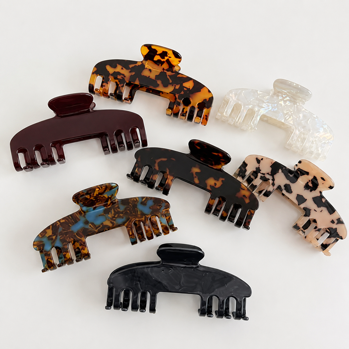 White iridescent RTS Hat Clips from P&PD Wholesale, shown attached to a hat for secure styling.
