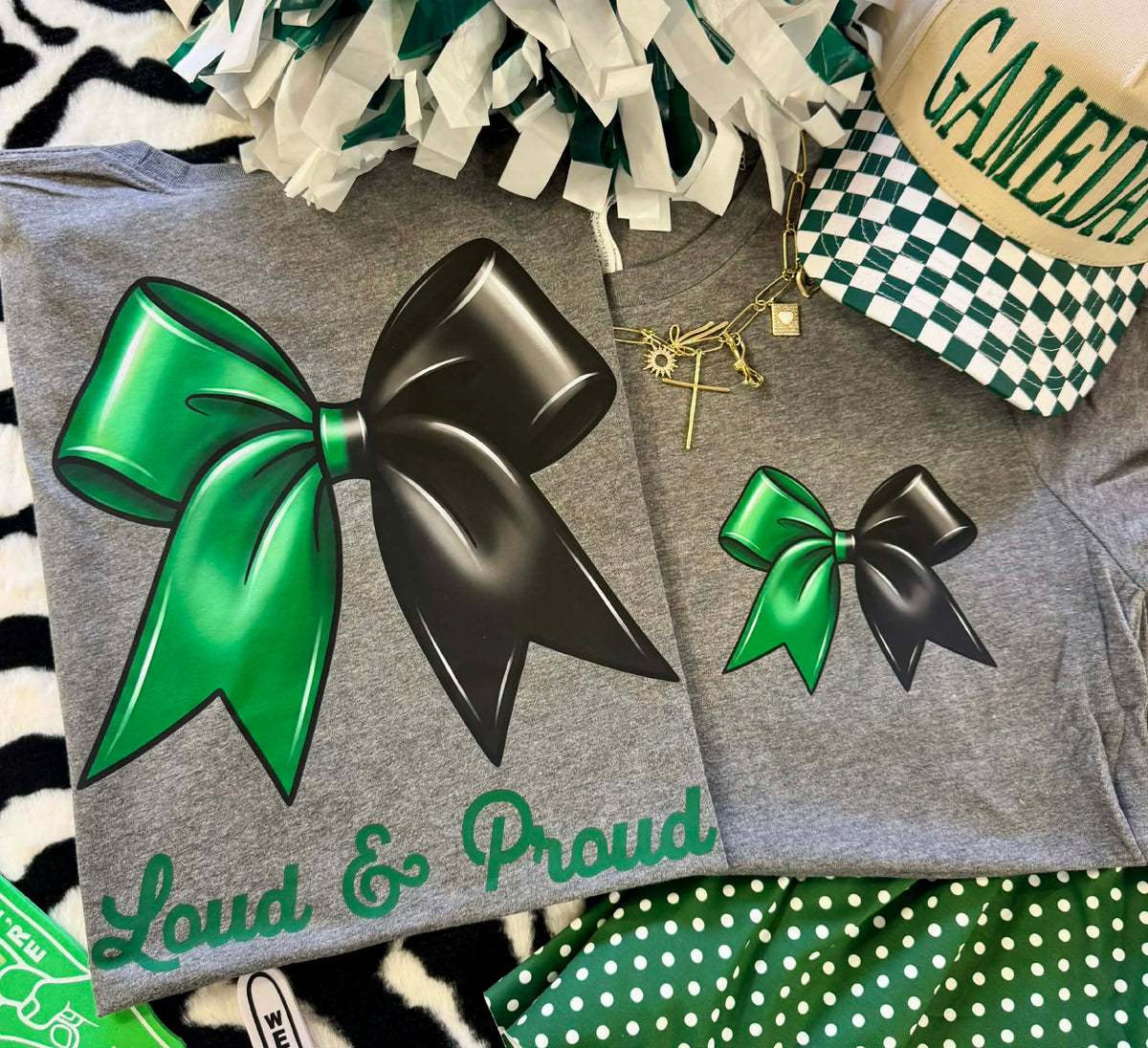 Green Bow Tee by P&PD Wholesale featuring bold lettering and a stylish design on a deep heather background.