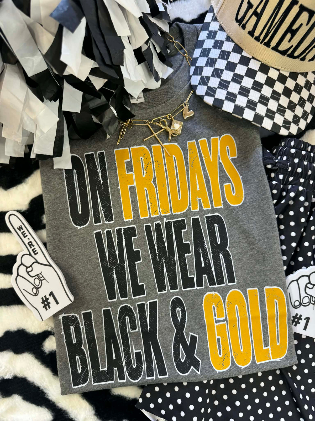 Deep heather black and gold "On Fridays We Wear Black and Gold" T-shirt by P&PD Wholesale, front view showing the graphic design.