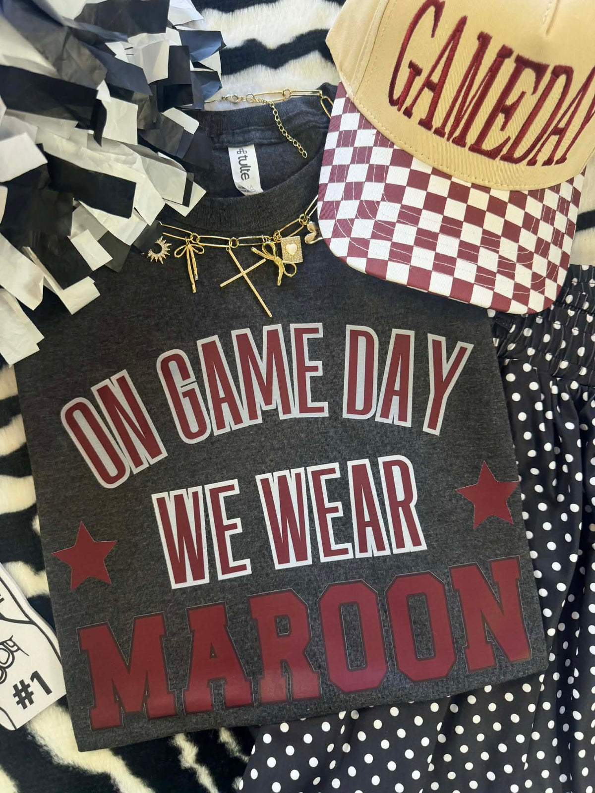 Maroon T-shirt from P&PD Wholesale featuring "On Fridays We Wear Maroon" text, shown on a heather charcoal background.