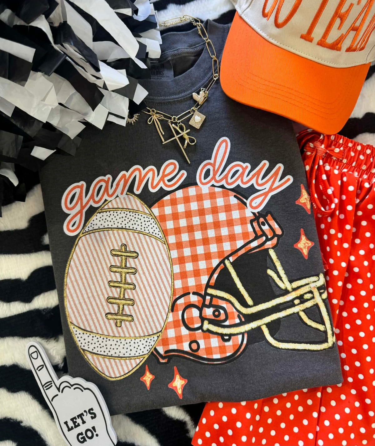 Orange gingham helmet tee by P&PD Wholesale, featuring a game day design and casual fit, perfect for sports fans.