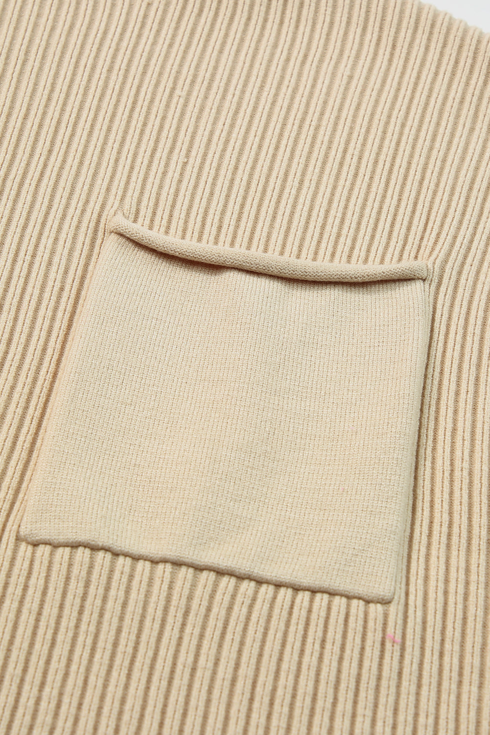 Shewin oatmeal patch pocket ribbed knit short sleeve sweater, close-up of beige knitted fabric with patch pocket detail.