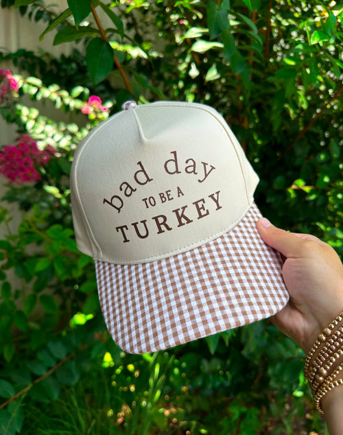 Khaki checkered trucker hat by Southern Bliss Co. featuring "Bad Day To Be A Turkey" embroidered design, casual outdoor style.