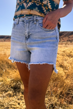 Sterling Kreek denim shorts featuring a classic blue wash, high-rise fit, and rolled cuffs, displayed on a white background.