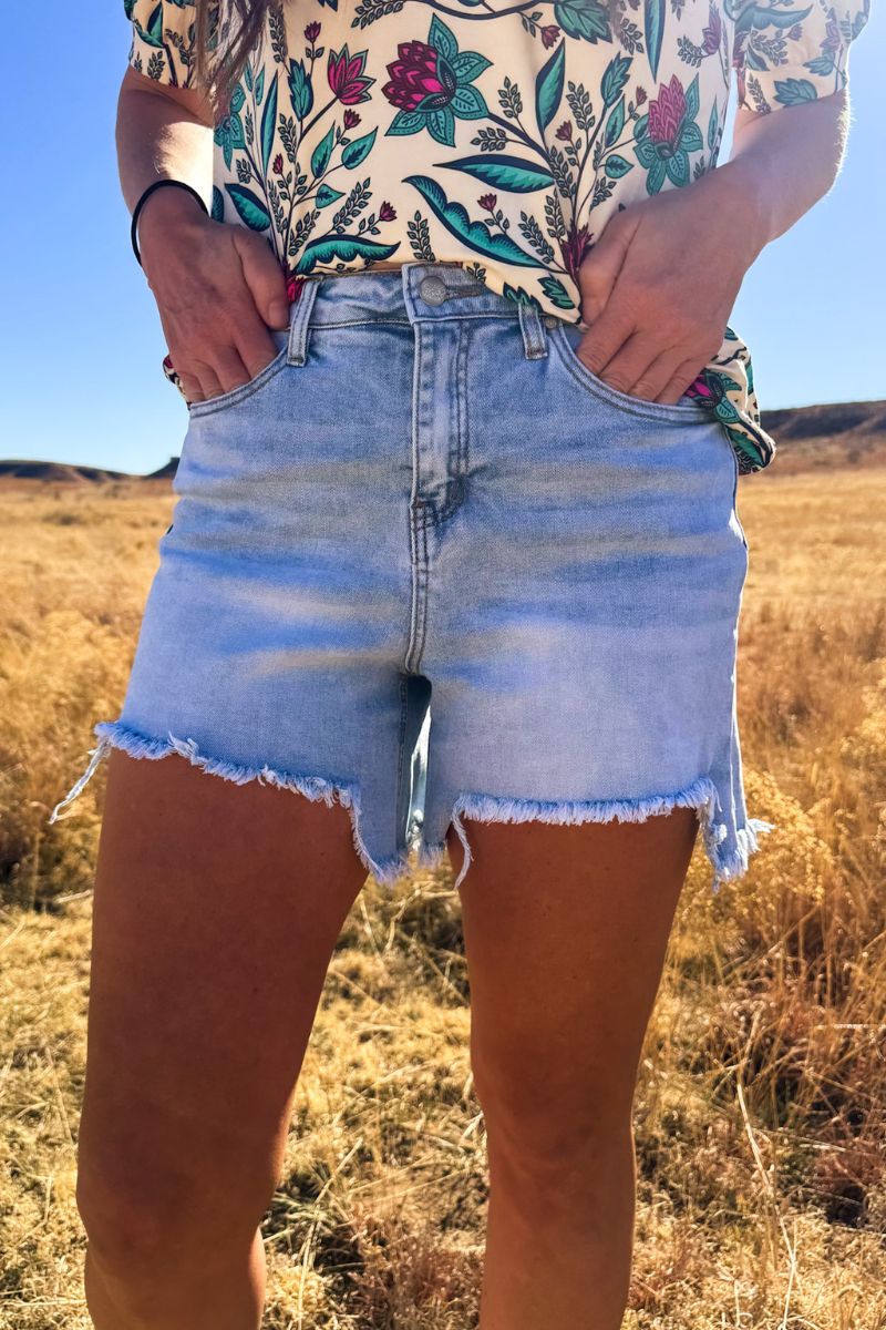 Sterling Kreek denim shorts featuring a classic cut, distressed details, and a light blue wash, casual summer fashion for women.