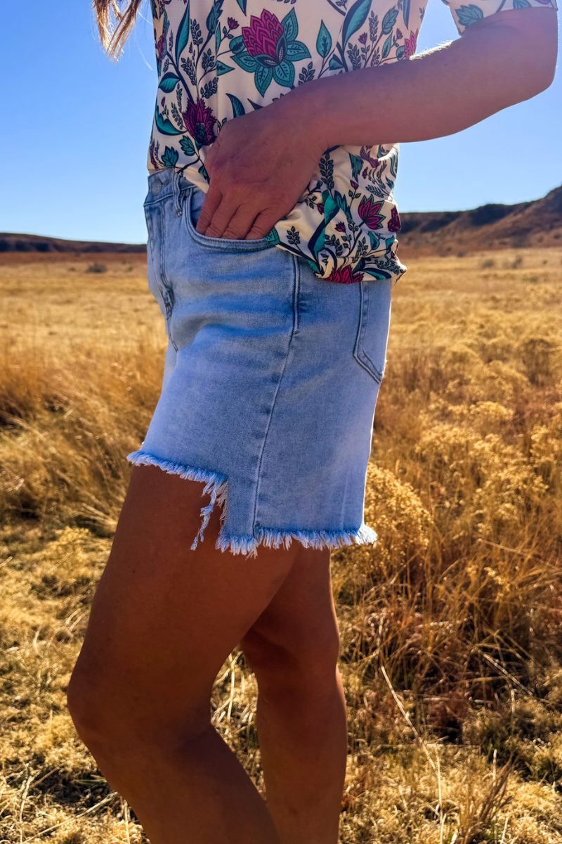 Sterling Kreek denim shorts with distressed details and frayed hem, casual summer style, front view.