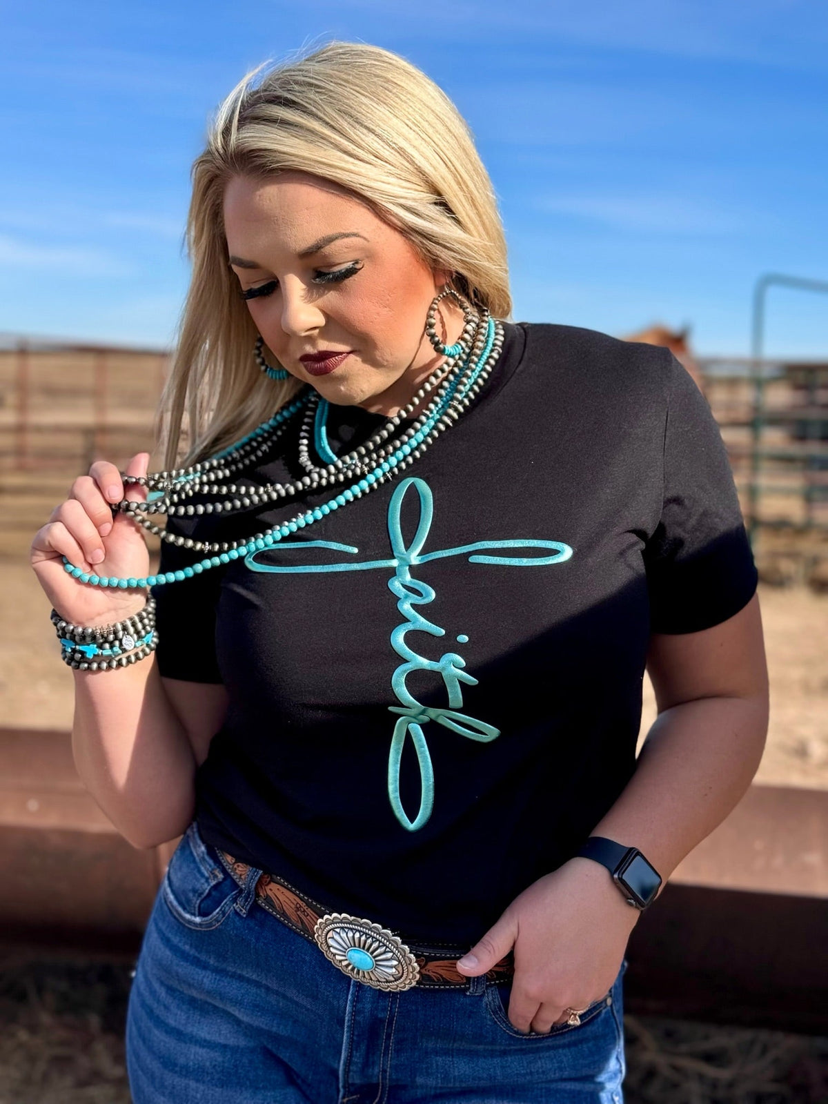 Black crewneck tee by Texas True Threads featuring a teal metallic puff of faith design on the front.