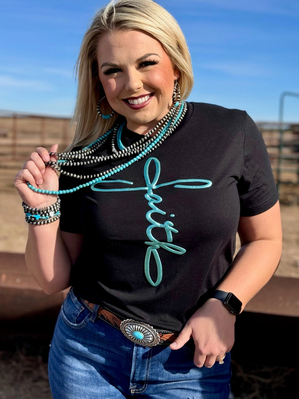 Black crewneck tee from Texas True Threads featuring a metallic teal puff design with the phrase "Faith in Teal."