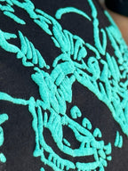 Black Texas True Threads Roughrider in Turquoise Puff Tee, crew neck t-shirt with graphic design, casual style.