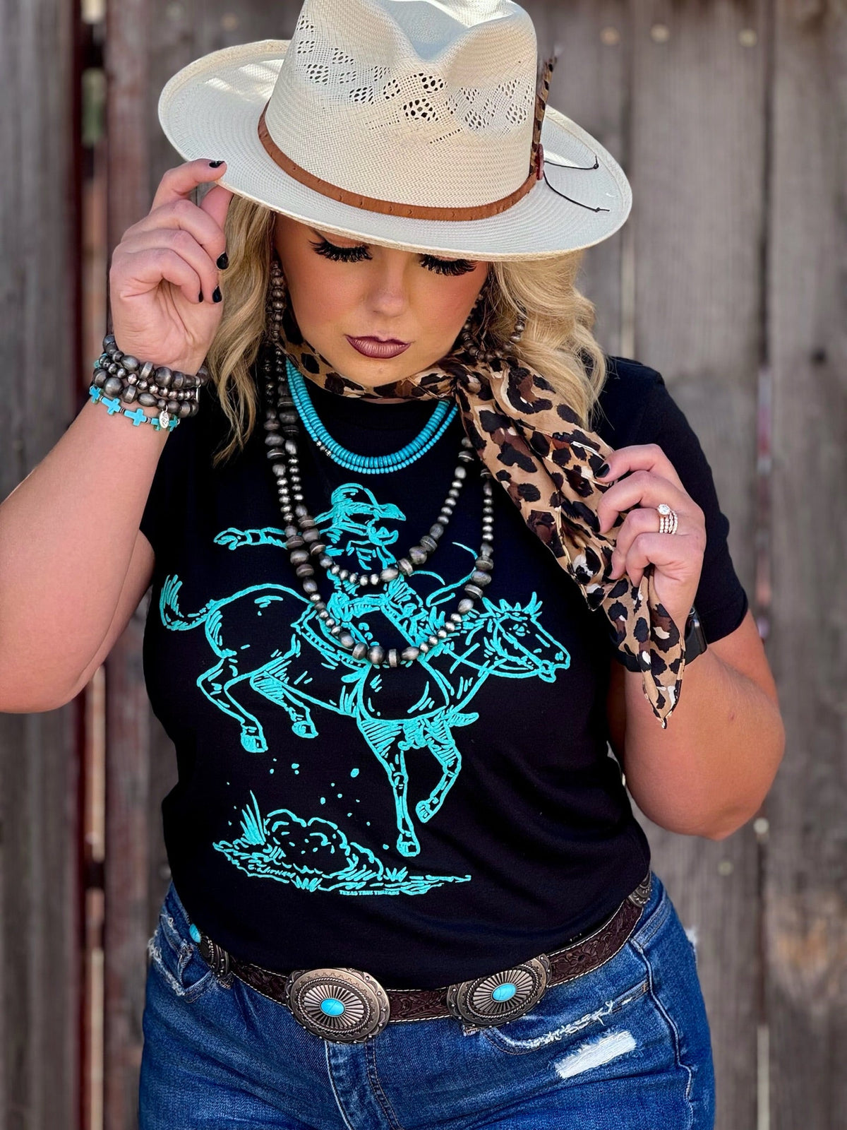 Texas True Threads Roughrider turquoise puff tee, black crew neck T-shirt with graphic design, casual unisex style.