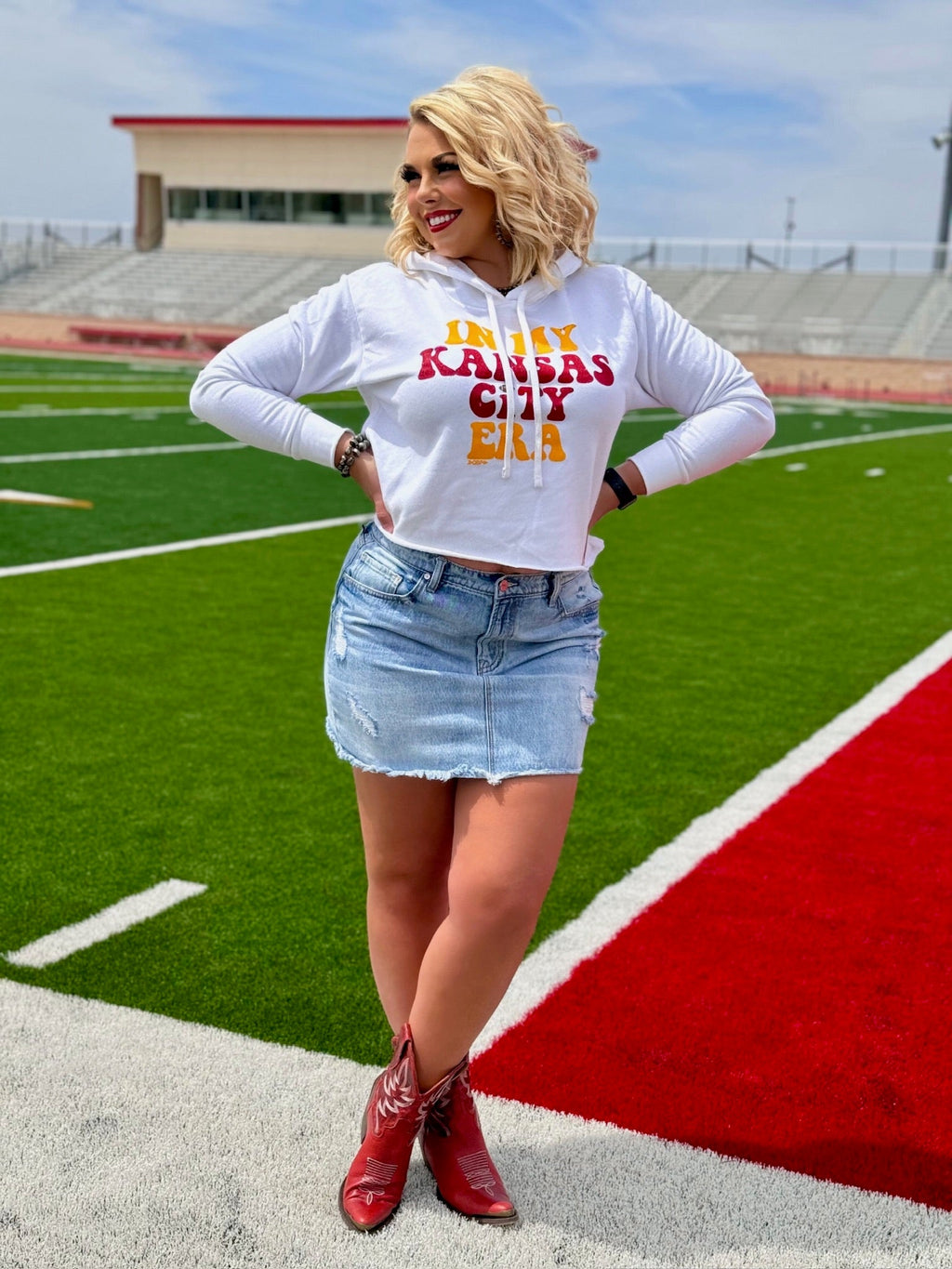 White crew neck tee by Texas True Threads featuring "In My Kansas City Era" text, styled with Randi Mahomes branding.