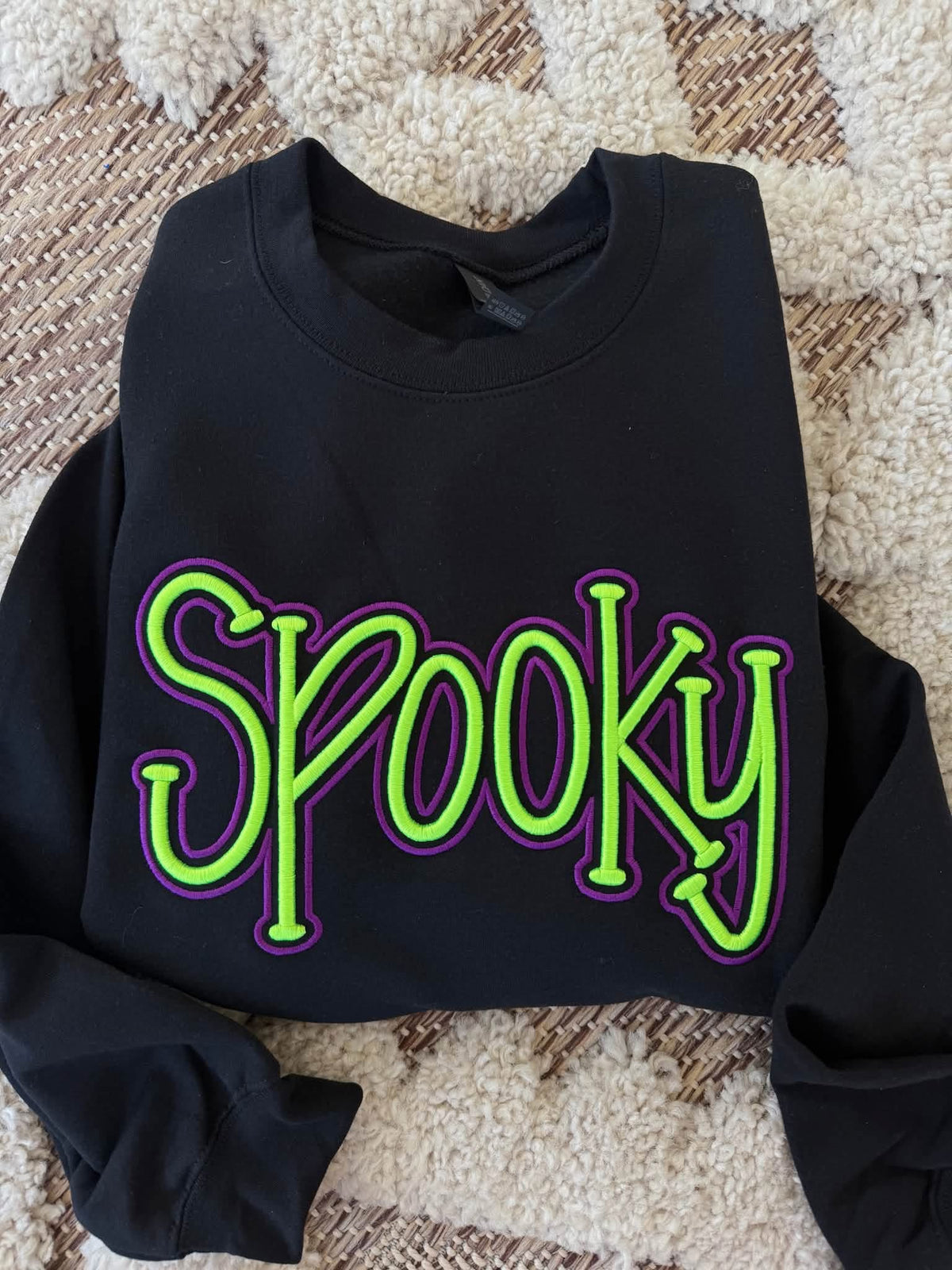 Black crewneck sweatshirt with spooky 3D embroidered leopard design, from Top Notch Wholesale.
