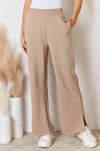 Tan RISEN wide waistband slit wide-leg pants from Trendsi, featuring a relaxed fit and stylish slit detail.