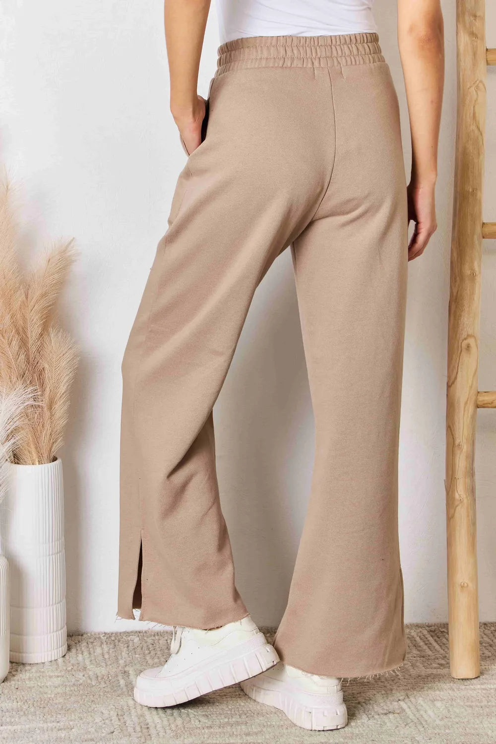 Tan RISEN wide waistband slit wide-leg pants from Trendsi, featuring a relaxed fit and flowy silhouette.