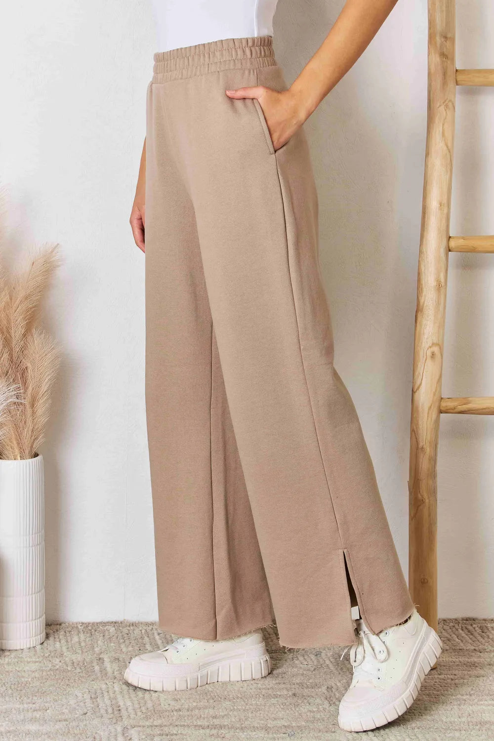 Tan RISEN wide waistband slit wide-leg pants with flowing fabric and relaxed fit, perfect for casual and stylish outfits.