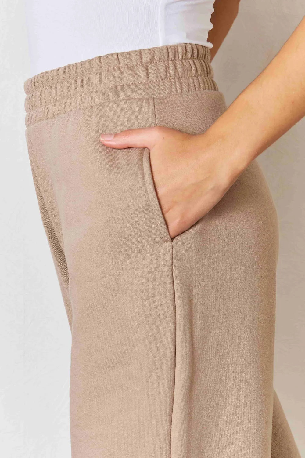 Tan RISEN wide waistband slit wide-leg pants with flowing fabric and relaxed fit, perfect for casual and stylish outfits.