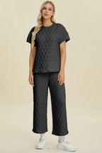 Black double take full-size texture round neck short sleeve top and matching pants set, trendy two-piece outfit by Trendsi.