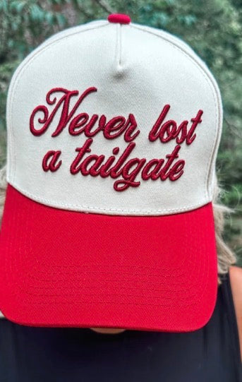 Crimson Wicker Road Never Lost A Tailgate hat with adjustable strap and embroidered design, suitable for outdoor events and tailgating.